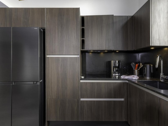 Cuisine moderne et élégante d'un penthouse à Avoriaz avec meubles en bois foncé et équipements haut de gamme.