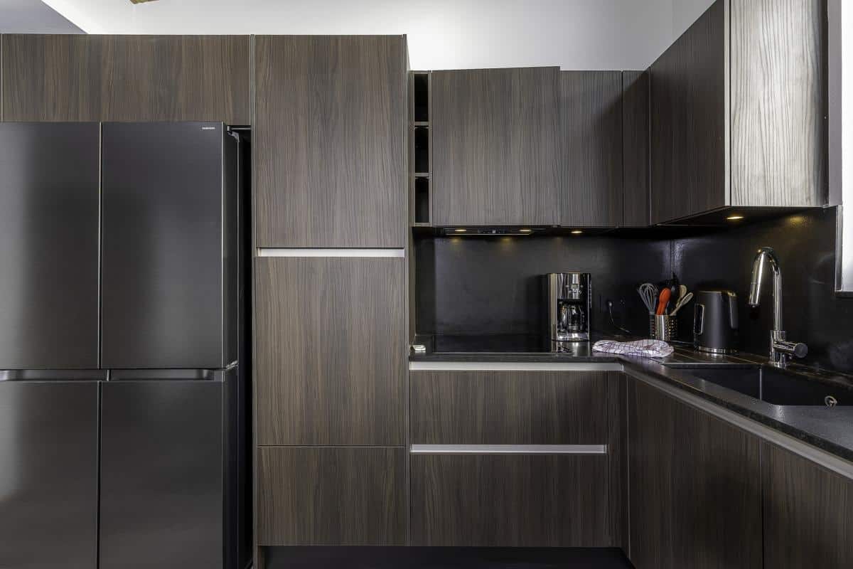 Cuisine moderne et élégante d'un penthouse à Avoriaz avec meubles en bois foncé et équipements haut de gamme.