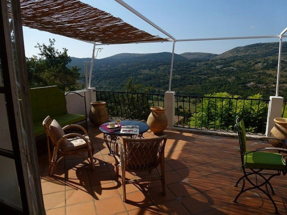 Terrasse d'une vaste demeure à Coursegoules avec vue sur les collines et la nature environnante.