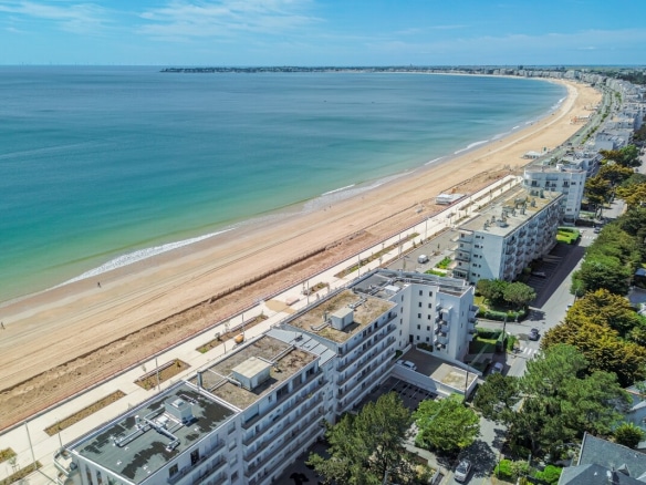 Vue aérienne de la plage de La Baule-Escoublac avec des bâtiments en bord de mer.