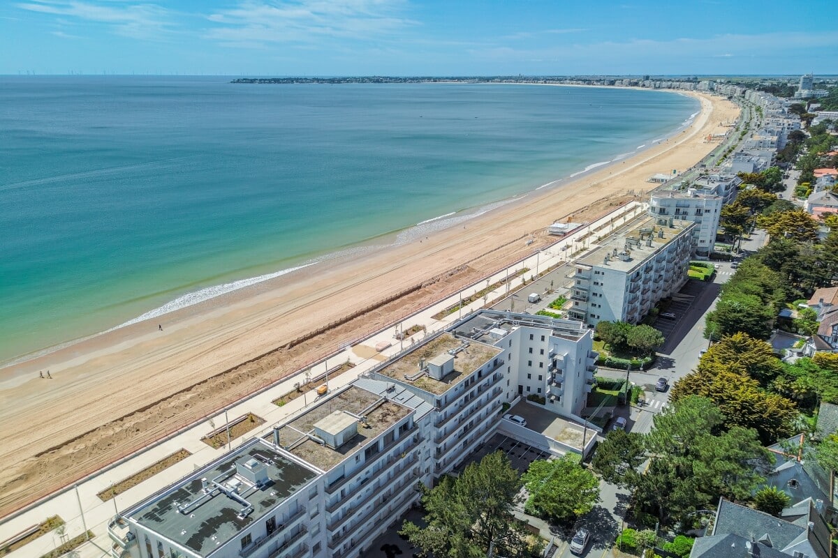 Vue aérienne de la plage de La Baule-Escoublac avec des bâtiments en bord de mer.