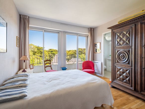 Chambre d'appartement avec lit double et fenêtres donnant sur la nature à La Baule-Escoublac.