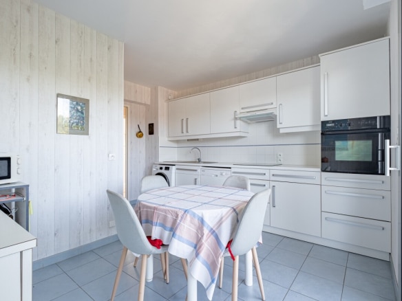 Cuisine moderne d'un appartement à La Baule-Escoublac avec table et chaises.