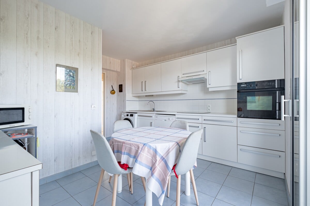Cuisine moderne d'un appartement à La Baule-Escoublac avec table et chaises.