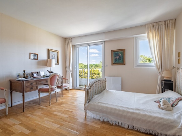 Chambre d'appartement avec lit et bureau, vue sur balcon à La Baule-Escoublac.