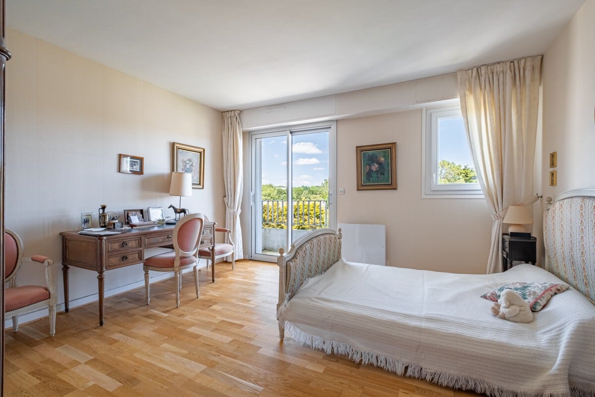 Chambre d'appartement avec lit et bureau, vue sur balcon à La Baule-Escoublac.