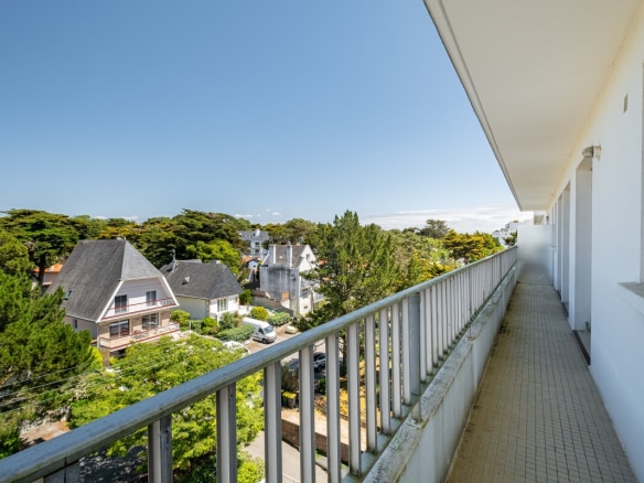 Balcon d'un appartement à La Baule-Escoublac avec vue sur des maisons et des arbres.