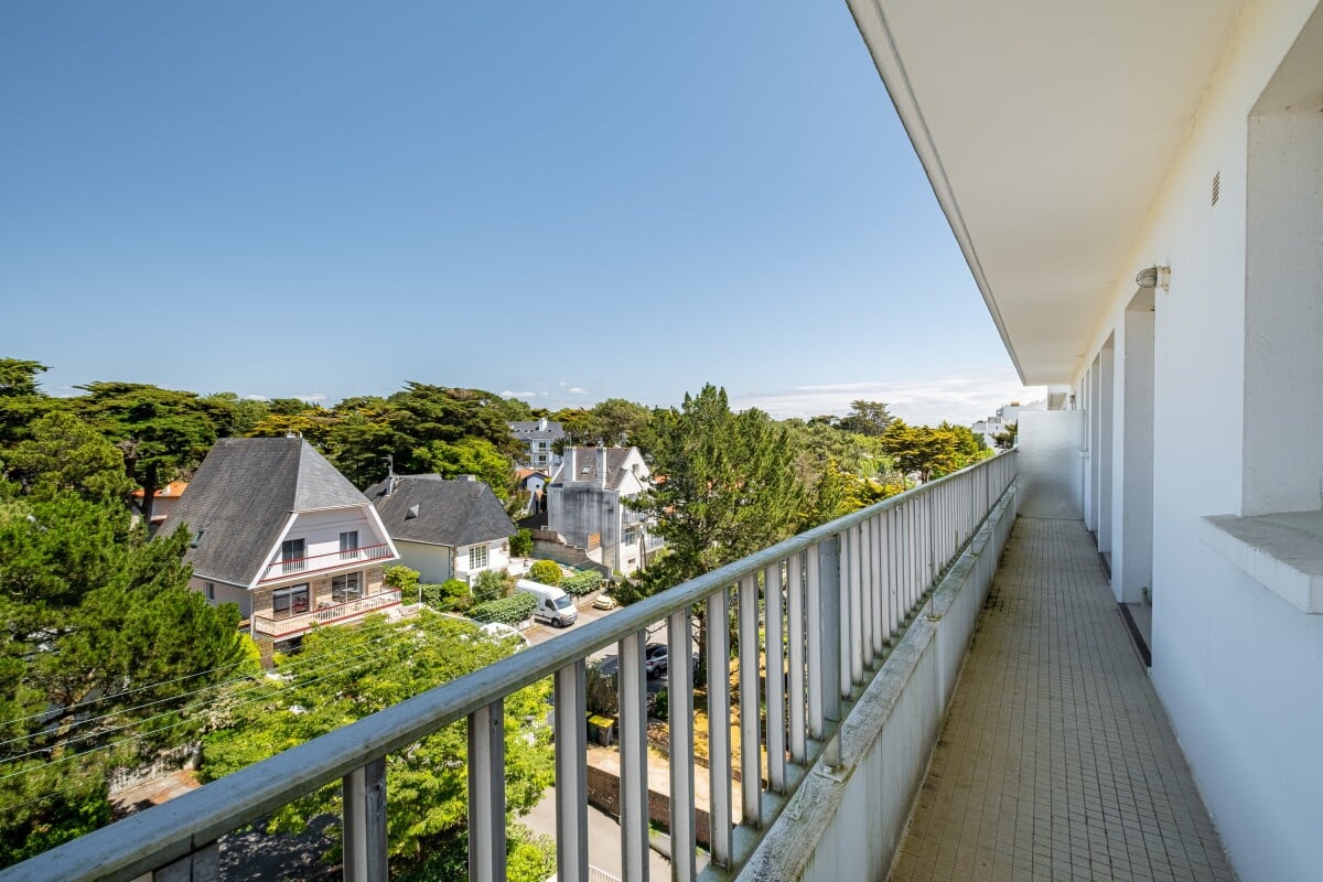Balcon d'un appartement à La Baule-Escoublac avec vue sur des maisons et des arbres.
