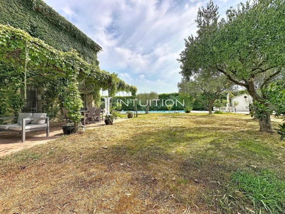 View of a Provençal villa with swimming pool and garden in Mougins, surrounded by trees.