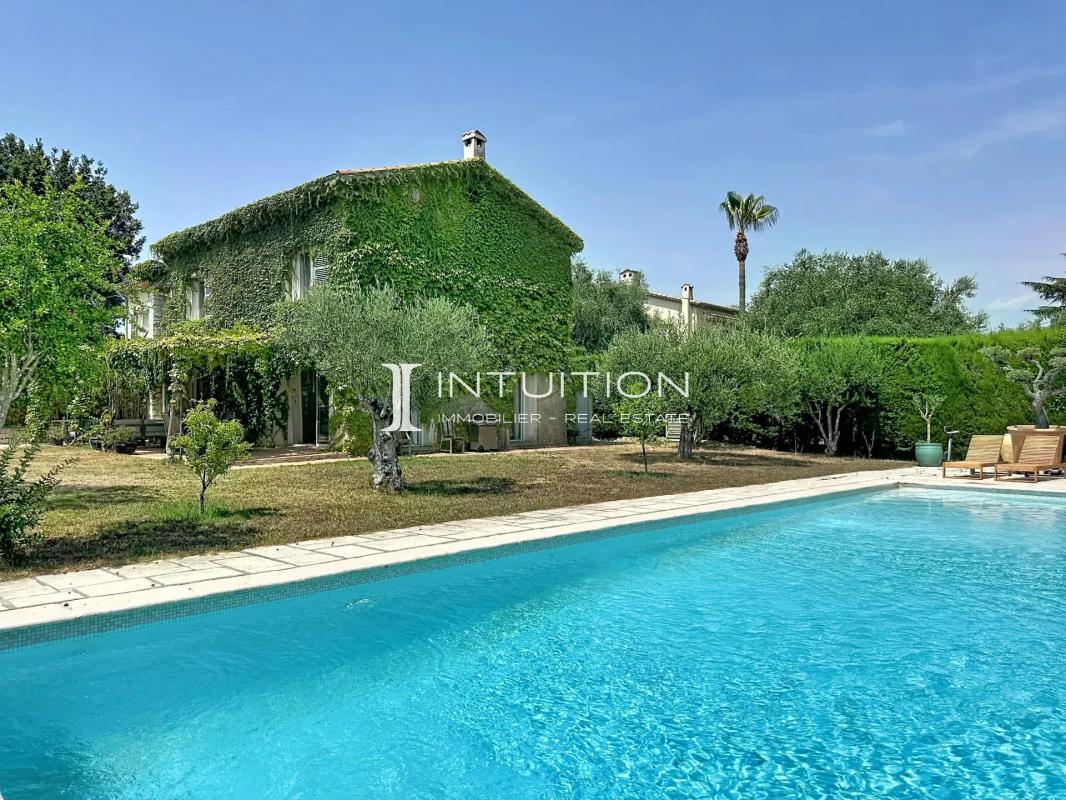Provençal villa with swimming pool and garden in Mougins, surrounded by trees and greenery.