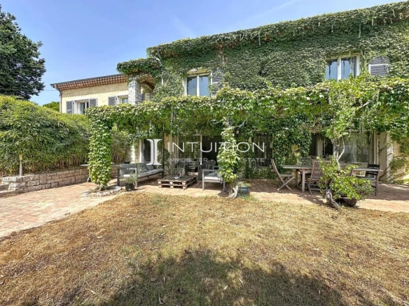 Provençal villa in Mougins with a greenery-covered facade and outdoor space.