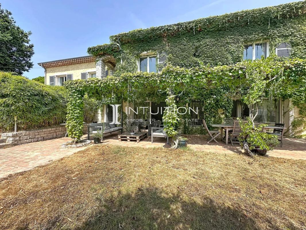 Provençal villa in Mougins with a greenery-covered facade and outdoor space.