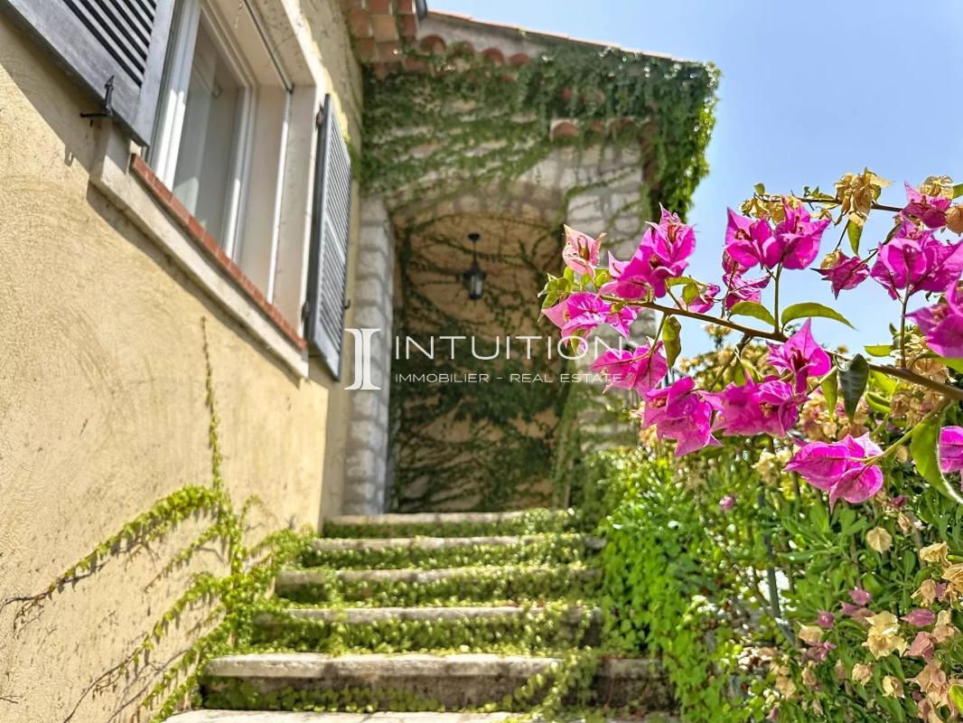 Staircase leading to a Provençal villa with flowers in the foreground.