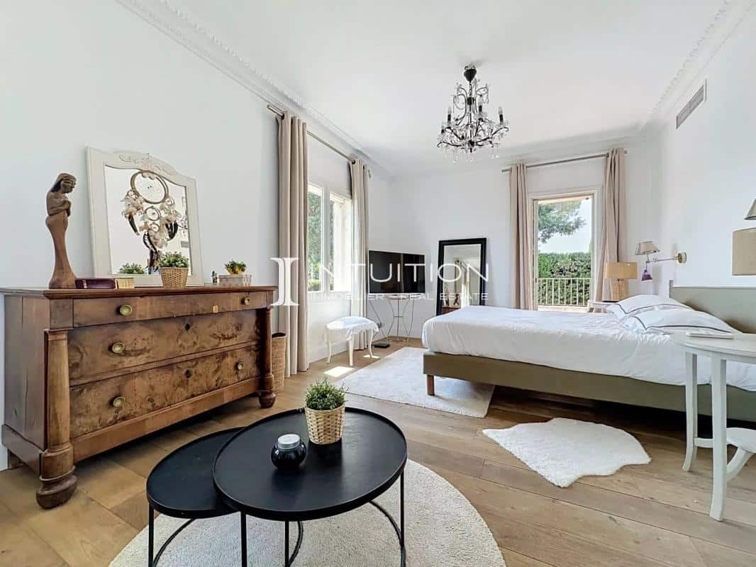Room in a villa in Mougins with bed, antique furniture and natural light.