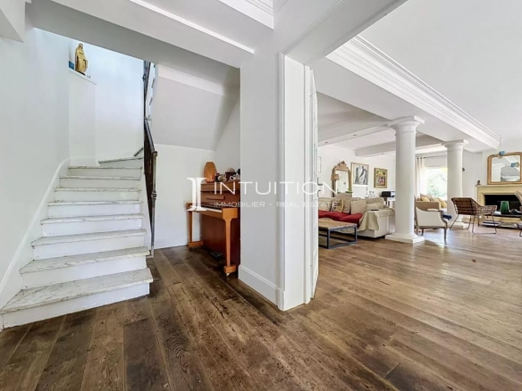 Interior of a villa in Mougins with a staircase and a large, bright living room.