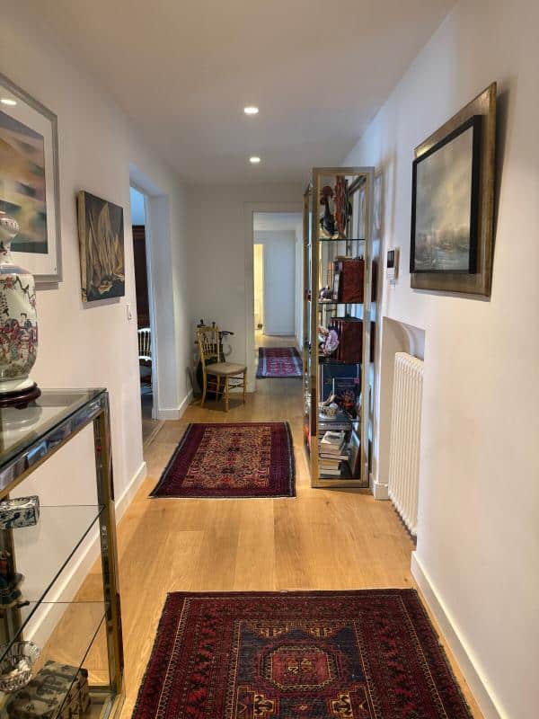 Hallway of an apartment in Biarritz with carpet and tasteful decor.