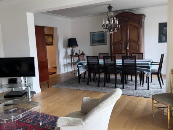 Interior of a spacious apartment with a living room and dining room, elegant furniture and natural light.