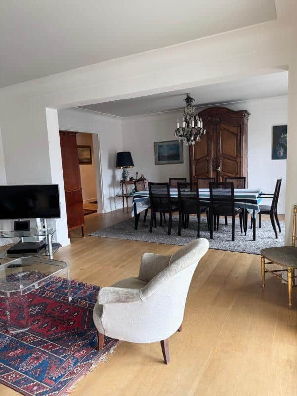 Interior of a spacious apartment with a living room and dining room, elegant furniture and natural light.