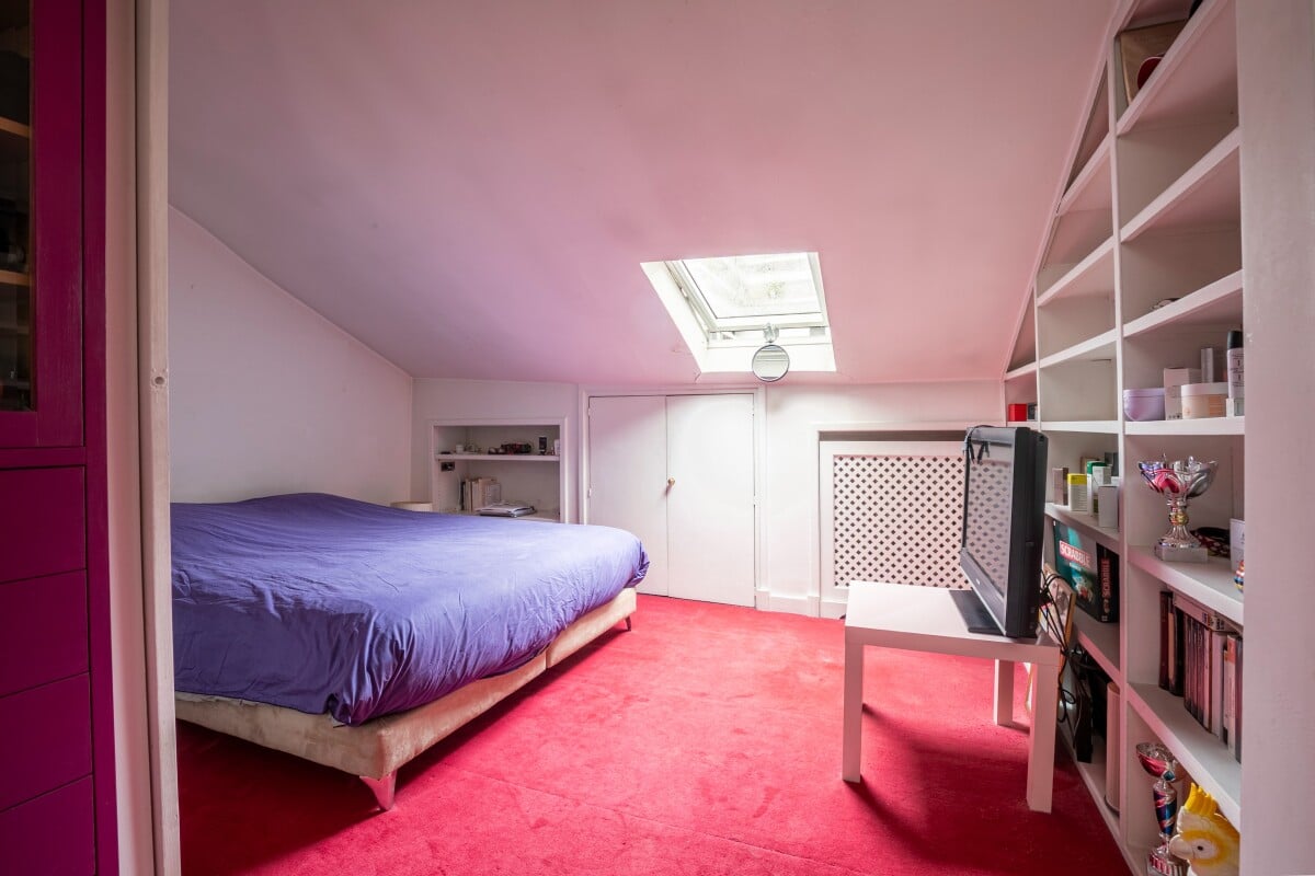 Bright studio apartment in the 16th arrondissement of Paris Artist's studio bedroom with a bed and a desk, natural light through a skylight.