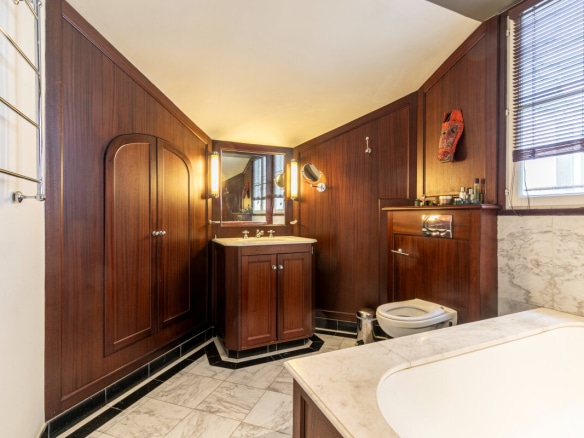Bathroom in an artist's studio in Paris, with wooden walls and a marble floor.