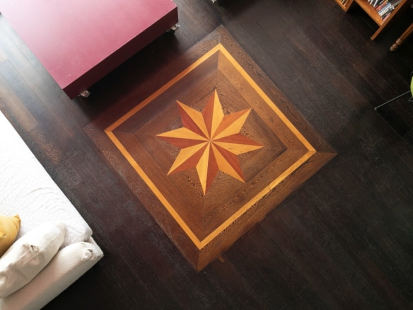 View of the wooden floor with a geometric star pattern in an artist's studio in Paris.