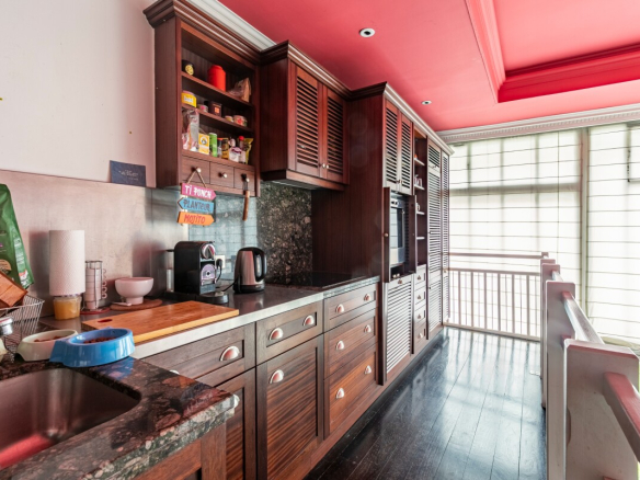 Kitchen in an artist's studio with wooden furniture and marble countertop, natural light in Paris 16th arrondissement.