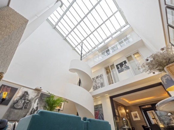 Interior of a private mansion in Paris 7, with a high ceiling and a spiral staircase.