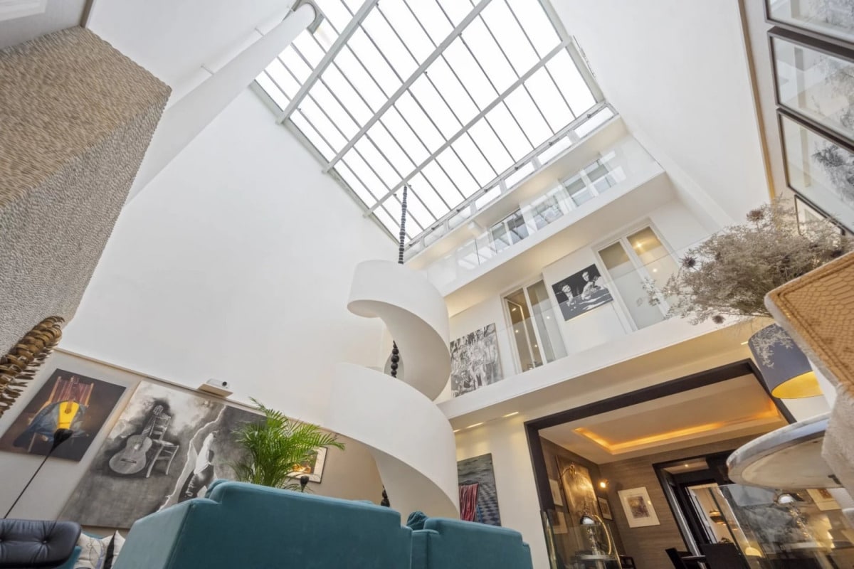 Interior of a private mansion in Paris 7, with a high ceiling and a spiral staircase.