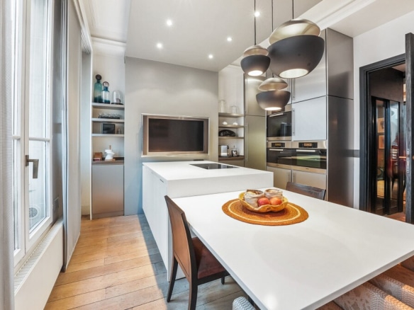 Modern kitchen with a large central island and high-end appliances in a Paris apartment.