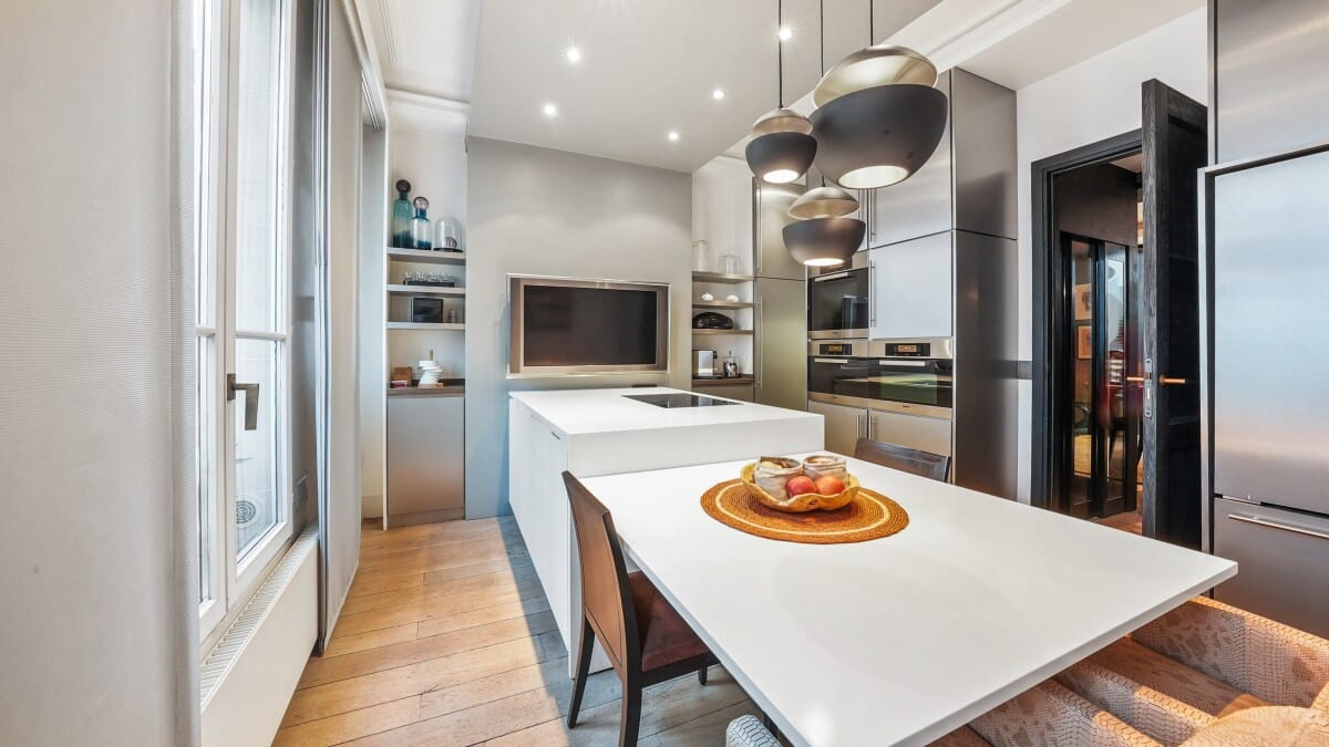 Modern kitchen with a large central island and high-end appliances in a Paris apartment.