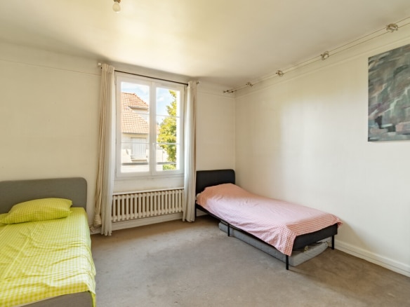 Room in a house in La Celle-Saint-Cloud with two single beds and a window.