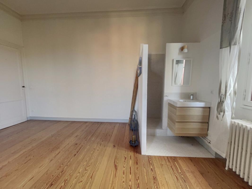 Renovated apartment in Arcachon Interior of a renovated apartment with parquet flooring, sink and partially visible shower.