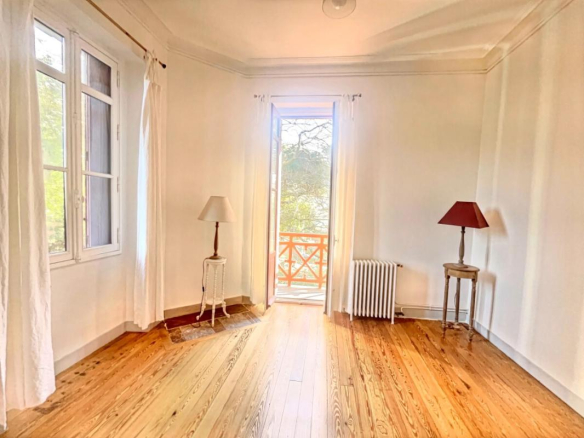 Bright living room in a renovated apartment in Arcachon with parquet flooring and fireplace.
