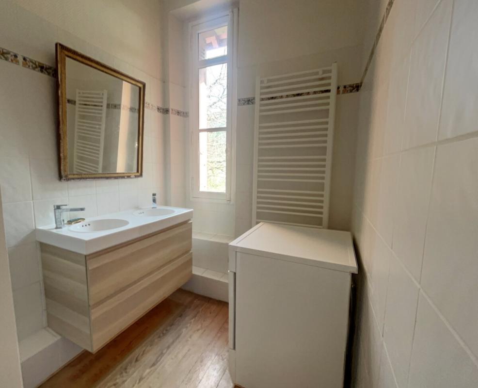 Renovated bathroom in Arcachon Renovated bathroom with vanity unit and bathtub, natural light
