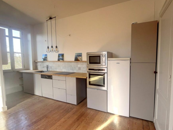 Modern and bright kitchen in a renovated apartment in Arcachon, with integrated appliances.