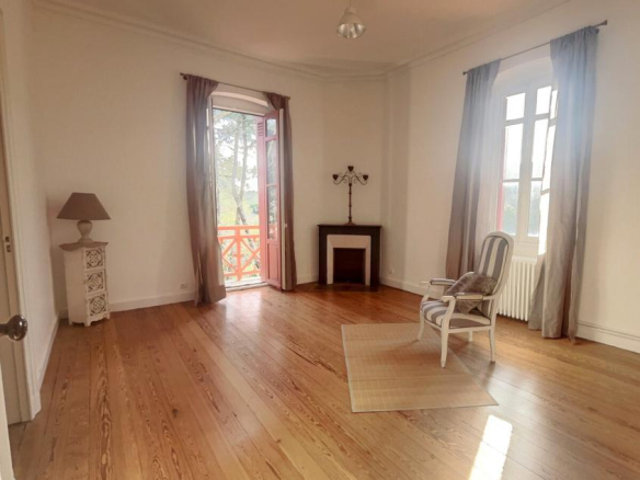Bright 30m² living room with parquet flooring and fireplace in an apartment in Arcachon.