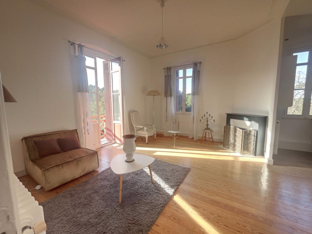 Apartment stay in Arcachon Bright living room in a renovated apartment in Arcachon with fireplace and parquet flooring.