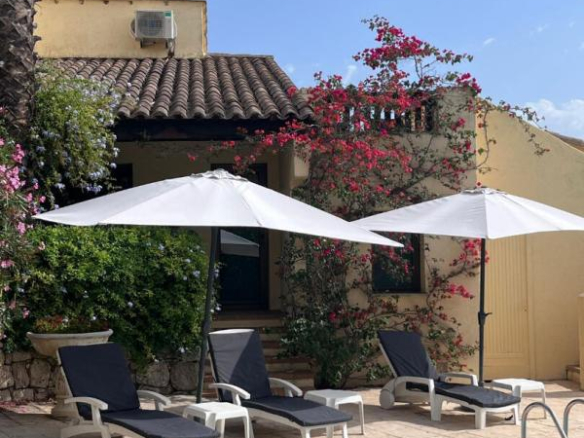 Terrace with sun loungers and parasols near the pool, surrounded by flowers in Gattières.
