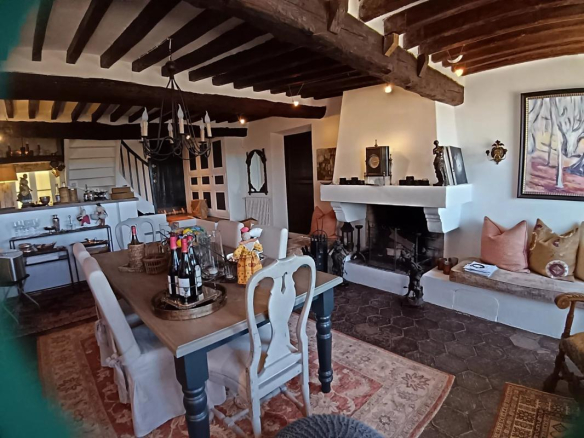 Intérieur d'une maison à Cagnes-sur-Mer avec cheminée, salle à manger et cuisine ouverte.