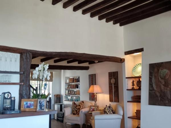 Intérieur d'une maison à Cagnes-sur-Mer avec poutres apparentes et coin salon accueillant.