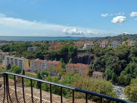 Vue depuis une terrasse surplombant des maisons et la mer à Cagnes-sur-Mer.