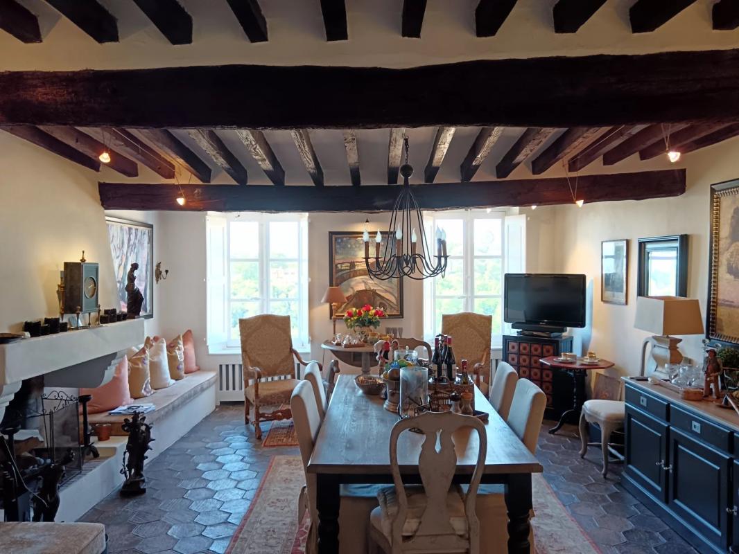 Intérieur d’une maison à Cagnes-sur-Mer Intérieur d'une maison avec salle à manger, cheminée et fenêtres lumineuses.