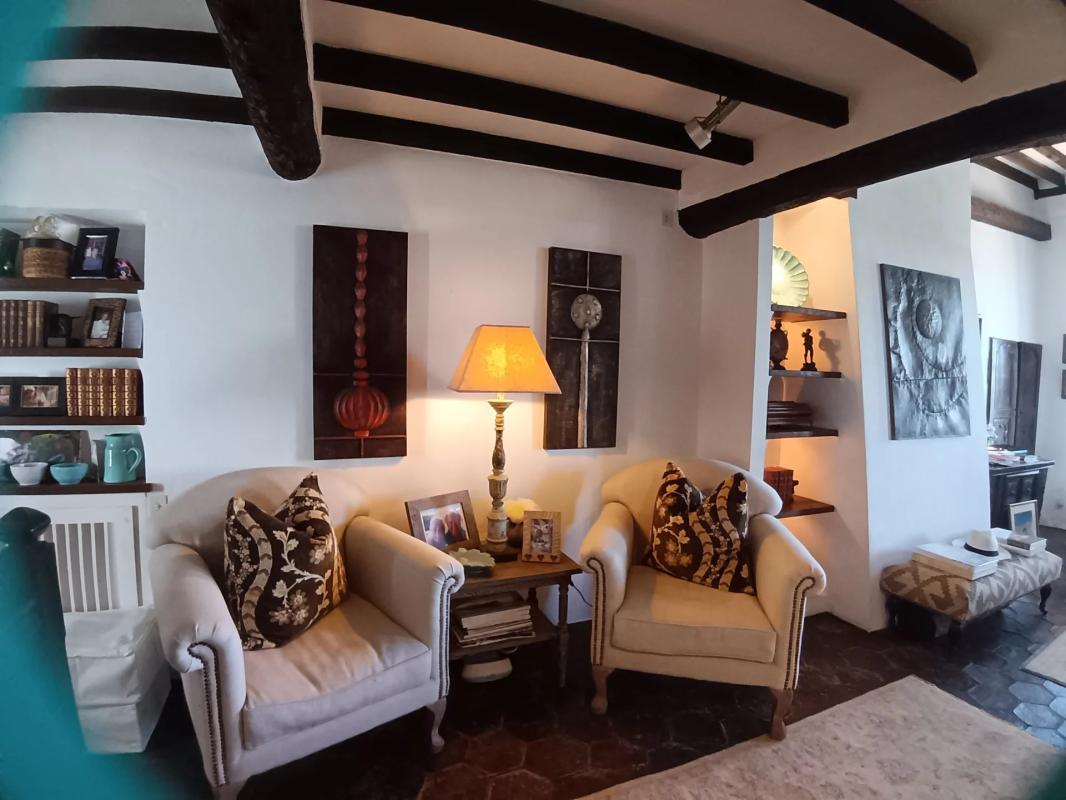 Intérieur d’une maison à Cagnes-sur-Mer Intérieur d'une maison à Cagnes-sur-Mer avec deux fauteuils, tables et décorations murales.