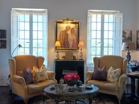 Intérieur d'une maison à Cagnes-sur-Mer avec deux fauteuils jaunes, table basse et fenêtres ouvertes.