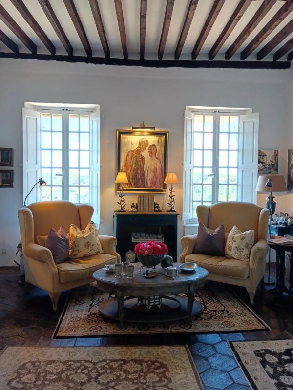 Intérieur de maison à Cagnes-sur-Mer Intérieur d'une maison à Cagnes-sur-Mer avec deux fauteuils jaunes, table basse et fenêtres ouvertes.