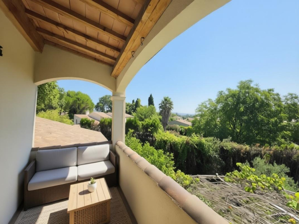 Terrace of a house overlooking gardens and trees in Paradou.
