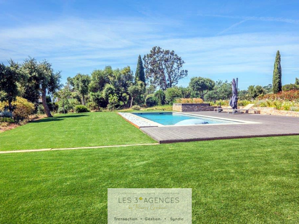 View of a garden with swimming pool and lawn in a contemporary villa in Grimaud.