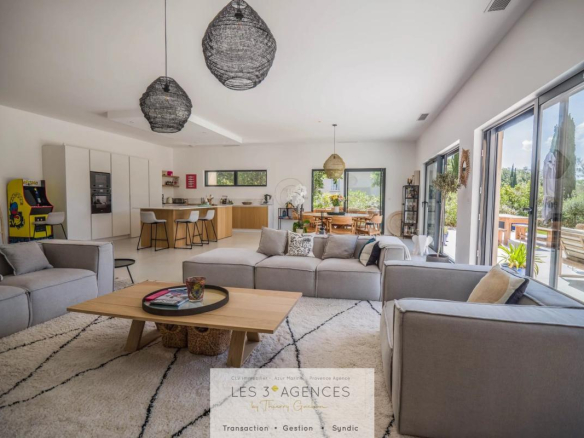 Interior of a contemporary villa in Grimaud with a spacious living room and open kitchen.