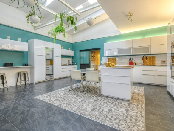 Modern and spacious kitchen with central island, natural lighting and contemporary decor.