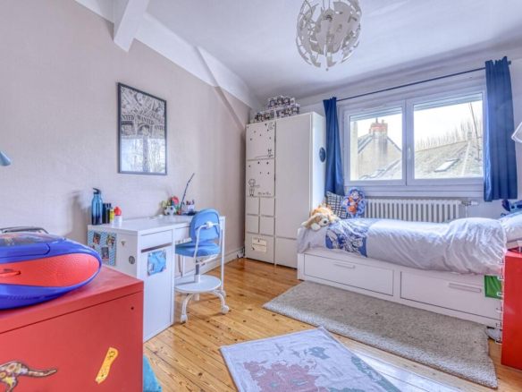 Bedroom in an apartment in Nantes with a bed, a desk and storage.